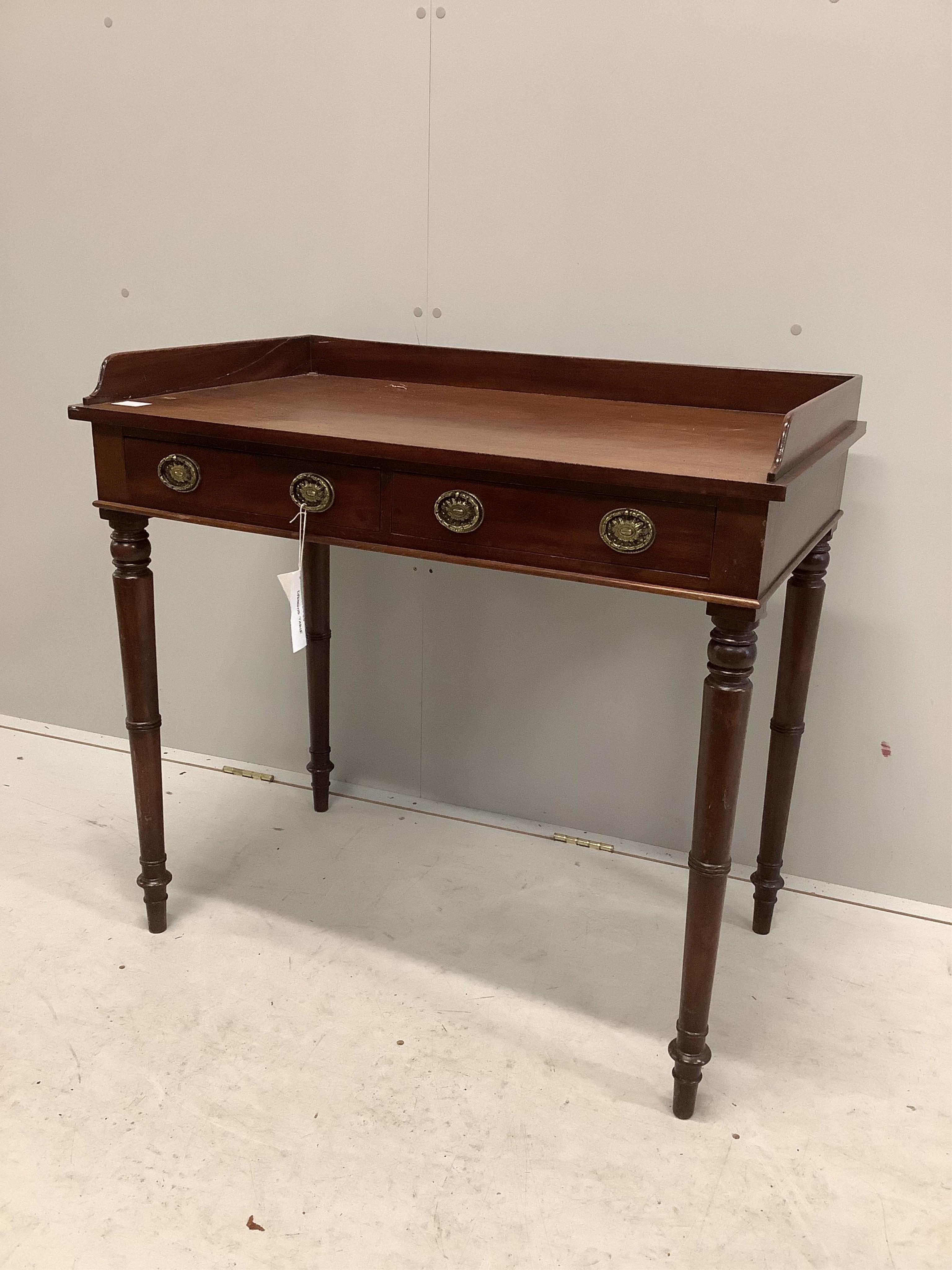 A Regency mahogany two drawer dressing table with a galleried top, on ring turned legs, width 91cm, depth 53cm, height 86cm. Condition - poor, one side to the gallery top is broken